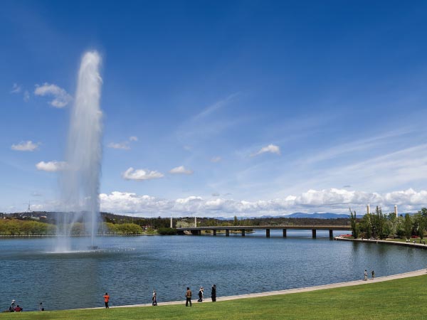 Fountain, Sky, Water, Water resources, Daytime, Cloud, Water feature, Architecture, Reflecting pool, River, Lake, Reservoir, Tourist attraction, Tourism, Lake Burley Griffin, Telstra Tower, Parliament House